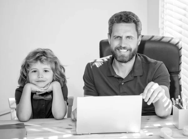 bearded dad or school private tutor teaching boy son with modern laptop, study online.