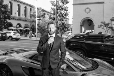 Patron lüks otomobilin yanında dur. Başarılı dağıtıcı. Satış. Araba sigortası. Otomobil fabrikası yakınlarında bir işadamı. Pahalı takım elbiseli yakışıklı bir girişimci. Kendine güvenen bir iş adamı araba kiralar.