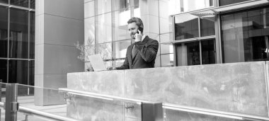 İş iletişimi ve akıllı telefondan konuşma. Pazarlık. Modern bilgisayar teknolojisi. e-postayı kontrol et Serbest çalışan adam blogu internete yükledi. İnternette yazıyorum. İş adamı blog için dizüstü bilgisayar kullanıyor.