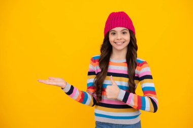 Kışlık kıyafetleri ve kalın şapkası olan liseli kız. Kış tatili. Çocuk manken. Mutlu ergen, pozitif ve gülümseyen genç kız duyguları