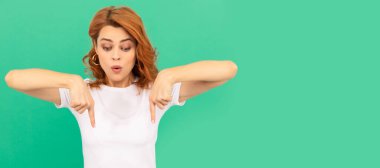 İzole edilmiş yüz portresi, fotokopi alanı olan pankart. Kıvırcık saçlı, parmaklarını aşağı gösteren şaşırmış bir kadın. Şuraya bak. Kadın model.