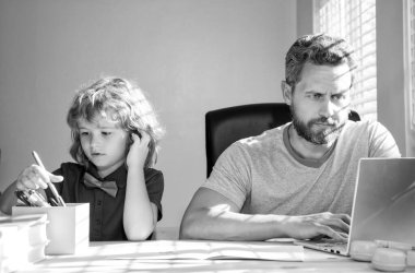 Olgun erkek öğretmen ya da baba çocuğa okul ödevlerinde yardım ediyor bilgisayar, evde eğitim....