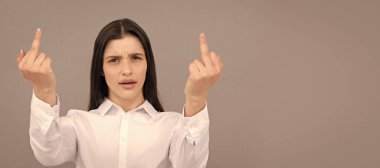 İzole edilmiş bir yüz portresi, taklit alanı olan bir afiş. Sinirli kadın orta parmağını gösteriyor. Saygısızlığı ifade etmek. Kötü kız. kaba agresif eller.