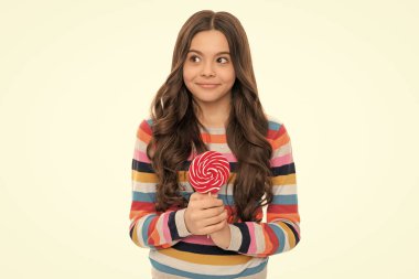Beyaz arka planda izole edilmiş lolipop şekerli renkli süveter giyen gülümseyen genç kız..
