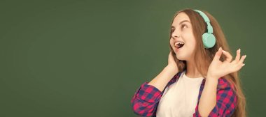 ok. happy teen girl in headphones. music lover. listen to music. wireless headset device accessory. Banner of schoolgirl student. School child pupil portrait with copy space