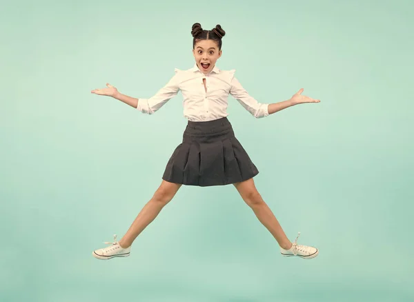 Excited face. Amazed expression, cheerful and glad. Happiness, activity and child. Teenager girl jumping on isolated background. Full length, energetic little girl jumping in air, child flying up