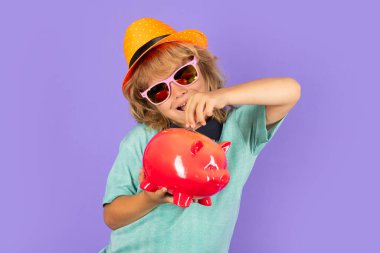 Alışverişe. Çocuk para biriktirmek için kumbaraya para koyuyor. Bozuk paralar ve çocuk konsepti olan kumbara.