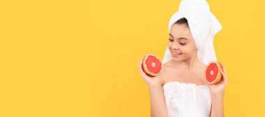 Sarı arka planda greyfurtlu havluyla mutlu bir çocuk. Genç çocuk için kozmetik ve cilt bakımı, poster tasarımı. Fotokopi alanı olan güzel kız afişi