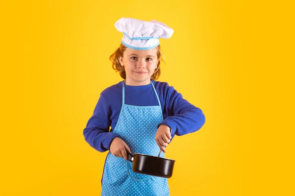 Kid chef cook with cooking pot stockpot. Chef child preparing healthy food. Studio portrait of child with chef hats