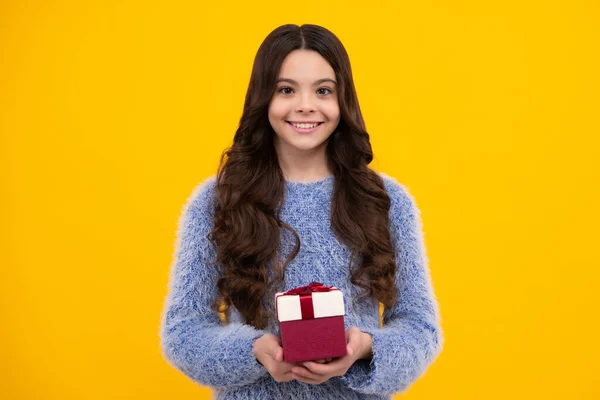 Child with gift present box on isolated background. Presents for birthday, Valentines day, New Year or Christmas. Happy teenager, positive and smiling emotions of teen girl