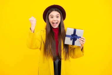 Teenager kid with present box. Teen girl giving birthday gift. Present, greeting and gifting concept. Excited teenager, glad amazed and overjoyed emotions