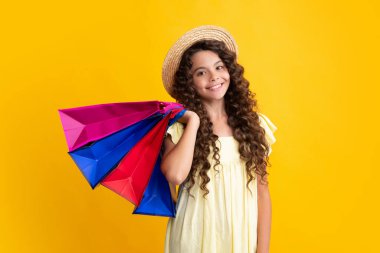 Stylish teen girl with shopping sale bags. Kid holding purchases. Happy teenager, positive and smiling emotions of teen girl