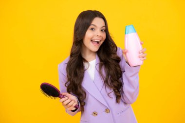 Şampuan kremi kullanan heyecanlı bir genç kız çocuğu. Günlük kozmetik bakım. 12, 13, 14 yaşlarındaki ergen çocuğun elinde saç ve cilt bakımı şişesi var. Güzellik sağlığı ve kozmetik