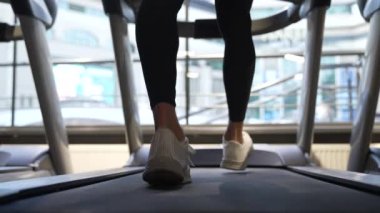 Spor ayakkabıları içinde spor ayakkabıları, spor salonunda koşu bandında yürüyüş, egzersiz. Koşu bandı egzersizi. Beden eğitiminde ve spor salonunda. Koşu bandı egzersiz ekipmanları. Yavaş çekim.