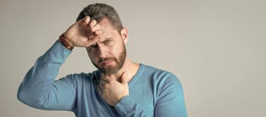 Sakallı olgun bir adamın gri arka planda Heacache hastalığı var. İnsan yüzü portresi, kopyalama alanı olan pankart