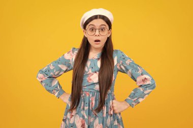 Şok olmuş ergen portresi sarı arka planda izole edilmiş. Şaşırmış genç kız. Şaşırmış yüz, şaşırmış genç kız duyguları.