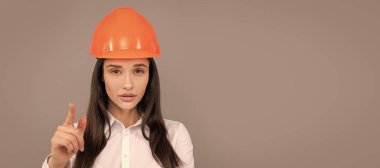 Koruyucu kasklı ve beyaz gömlekli ciddi kadın patron kamerayı işaret ediyor, kadın patron. İzole edilmiş yüz portresi, taklit alanı olan pankart