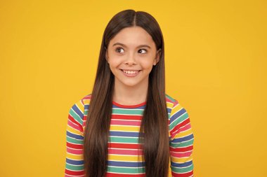 Mutlu yüz, pozitif ve gülümseyen genç kız duyguları. Sarı arka planda çocuk stüdyosu portresi. Çocukluk yaşam tarzı konsepti. Sevimli genç kız yüzü. Yakından.