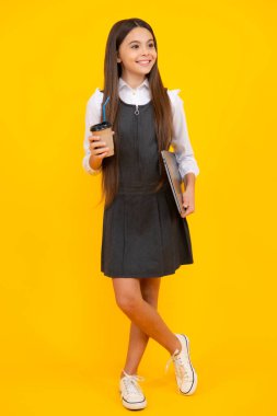 Sarı stüdyo arka planında kahve ya da çay fincanı olan çocuk. İçki ısmarlayan ergen kız.