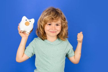 Para biriktirmek için kumbara. Çocuk kumbarayı tutuyor. Kumbaralı çocuk