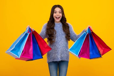 Alışveriş torbaları çocukların elinde. Alışverişten sonra genç bir kız. Satın alma, kara cuma, indirim ve satış konsepti. Mutlu ergen, pozitif ve gülümseyen genç kız duyguları