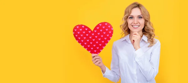 happy woman with red love heart on yellow background, valentines sale. Woman isolated face portrait, banner with mock up copy space