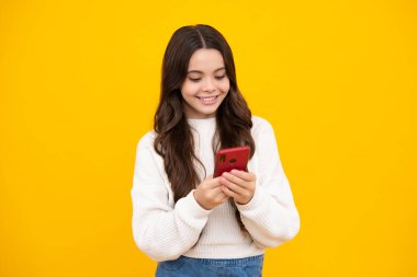 Cep telefonu kullanan, internette sohbet eden, SMS yazan güzel bir genç kızın portresi. Akıllı telefon için mobil uygulama. Çocuk yaşam tarzı konsepti. Kopyalama alanı oluşturun. Mutlu yüz.