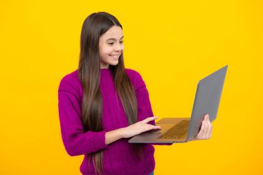 Genç kız öğrenci bilgisayarı tutuyor. Sarı arka planda dizüstü bilgisayarı olan komik bir öğrenci. Okula geri dön.