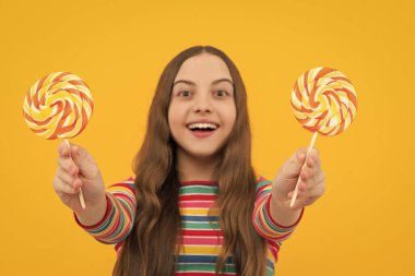 Hippi ergen kız lolipopu yalıyor. Şeker, şeker ve şekerleme. Çocuk lolipop şekeri yiyor.