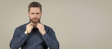 Zahmetsizce zeki görünüyorsun. Tıraşsız adam düğmesi, gri arka plan. Havalı giyiniyor. İnsan yüzü portresi, kopyalama alanı olan pankart