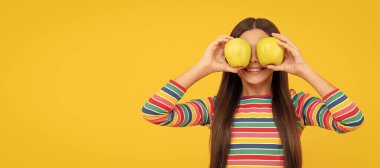 Apples improve your eyesight. Happy child hold apples at eyes. Fruit for good eye health. Child girl portrait with apple, horizontal poster. Banner header with copy space