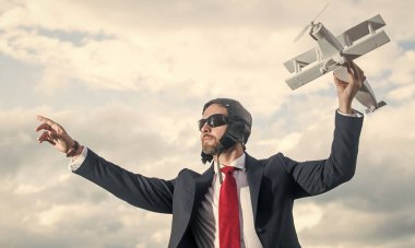 Takım elbiseli yönetici ve pilot şapkalı uçak oyuncağı..