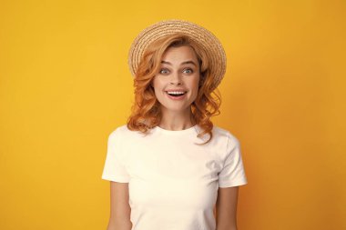 Kızıl saçlı, güzel, saman şapkalı, şaşkın bir kadın. Yaz havası. Genç, gülümseyen, beyaz, güzel, yaldızlı kızıl saçların portresi.