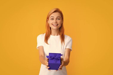 İyi ki doğdun Elinde kurdeleli hediye kutusu olan bir kadın. Sarı arkaplan üzerinde stüdyo resmi