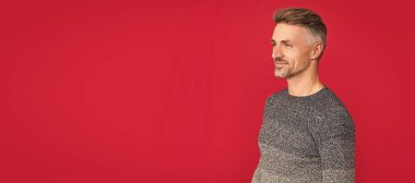 İnsan yüzü portresi, fotokopi alanı olan pankart. Kış modası. Erkek güzelliği. Saç ve cilt bakımı. Süveter giyen neşeli, kır saçlı adam