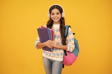 Okula dönelim. Okul çantalı kulaklıklı liseli kız öğrenci izole stüdyo geçmişi üzerine kitap tutuyor. Okul ve eğitim kavramı