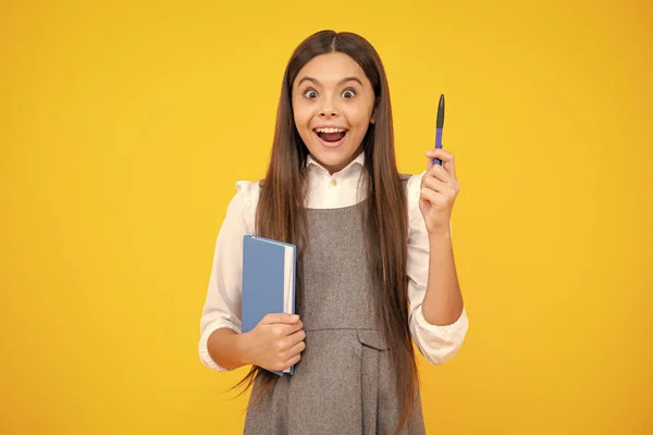 Excited face. Teen girl pupil hold books, notebooks, isolated on yellow background, copy space. Back to school, teenage lifestyle, education and knowledge. Amazed expression, cheerful and glad