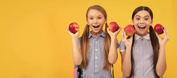 Eat fruit to be cute. Happy school friends hold apples. Healthy eating. Always eat right. Child girl portrait with apple, horizontal poster. Banner header with copy space