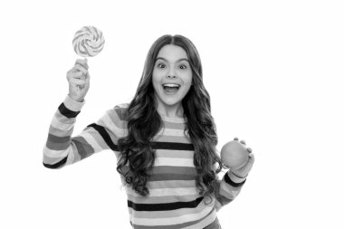 Süveterli, turuncu meyveli, lolipoplu, beyaz tenli, öğle yemeği yiyen bir çocuk..