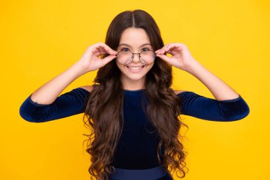 Mutlu yüz, pozitif ve gülümseyen genç kız duyguları. Oftalmolog, genç kızın gözlüğünü takıyor, yakın plan. Gözlüklü çocuk bakışı tedavisi