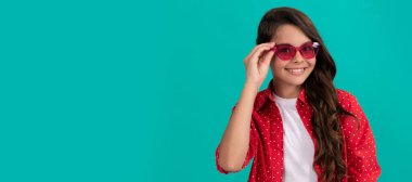 Genç bir kızın güzel görünüşü. Mavi arka planda çocuk portresi. Çocuk yüzü, yatay poster, izole edilmiş genç kız portresi, fotokopi alanı olan pankart