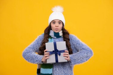Komik kız suratı. Hediye kutusu olan ergen bir çocuk. Tatil hediyesi. Mutlu yıllar, Sevgililer Günü, Yeni Yıl ya da Noel. Çocuk hediye kutusunu tut