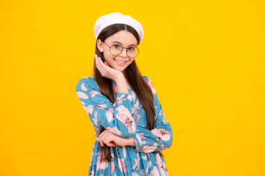 Sarı arka planda çocuk stüdyosu portresi. Çocukluk yaşam tarzı konsepti. Sevimli ergen kız yüzünü yakından çek. Mutlu ergen, pozitif ve gülümseyen duygular