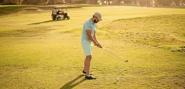 Golf sopasıyla şapkalı golfçü çimlerde, sporda oynuyor..