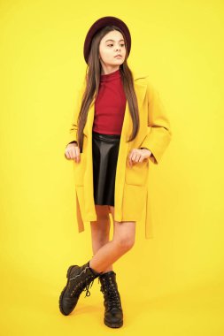 Stüdyoda sarı arka planda izole edilmiş genç kız kıyafetleri. Çocuk yaşam tarzı konsepti