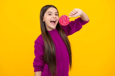 Heyecanlı bir yüz. Şekerli lolipopu olan genç bir kız, 12, 13, 14 yaşlarında şeker yiyip şeker yiyen mutlu bir çocuk. Şaşırtıcı bir ifade, neşeli ve mutlu.