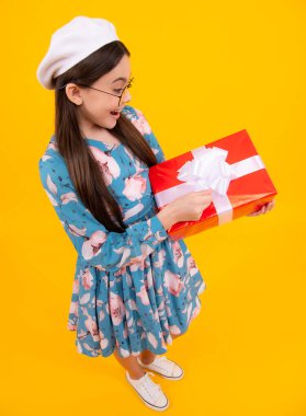 Child with gift present box on isolated background. Presents for birthday, Valentines day, New Year or Christmas. Happy teenager, positive and smiling emotions