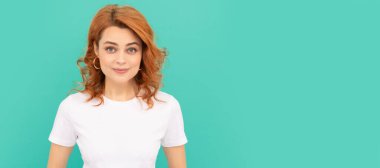 Mavi arka planda kıvırcık saçlı neşeli kızıl kadın. İzole edilmiş yüz portresi, kopyalama alanı olan pankart