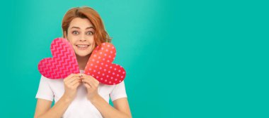 Mavi arka planda kırmızı kalpli genç bir bayan. İzole edilmiş yüz portresi, kopyalama alanı oluşturulmuş pankart