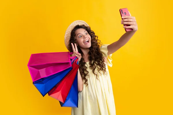 Teenager hold shopping bag and mobile phone enjoying sale. Child girl is ready to go shopping. Summer shopping sale. Happy teenager, positive and smiling emotions of teen girl
